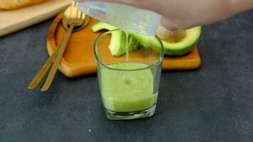 Masculin mains verser Avocat jus obtenu de une smoothie. video