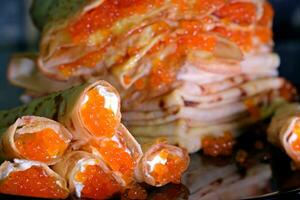 Pancakes with red caviar , black caviar with Feta cheese decorated with herbs. Delicious Healthy Food photo