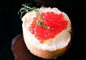 Sandwiches with red caviar, decorated with herbs on a dark background. Delicious Healthy food Breakfast lunch dinner photo