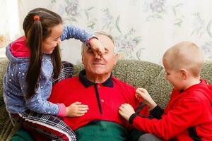 grandfather spends time with grandchildren in the living room photo