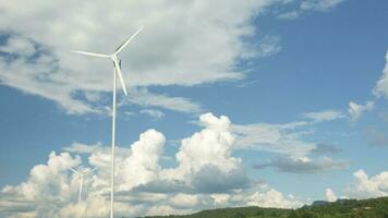 el blanco molinos de viento en azul cielo y nubes fondo, giro en viento a generar limpiar eléctrico energía industria, natural poder recurso tecnología para sostenible ecología y ambiente conservación. foto