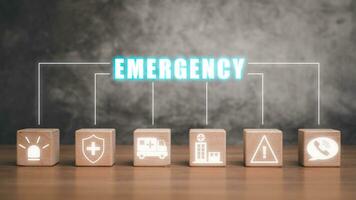 Emergency concept, Wooden block on desk with emaergency icon on virtual screen. photo