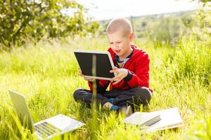 niños, educación, aprendiendo, tecnología concepto. pequeño chico con ordenador portátil computadora. eso educación. elemental escuela. niño chico utilizando ordenador portátil. linda pequeño niño chico estudiando o jugando juego con ordenador portátil. foto