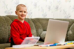 contento chico sentado a su escritorio con ordenador portátil computadora foto