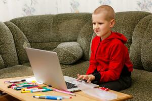 Young boy doing homework at the table at home photo