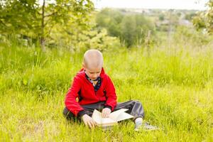 Portrait of a boy sitting with a book in the park photo