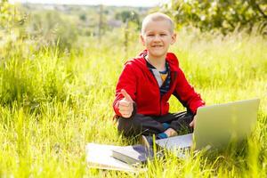 niños, educación, aprendiendo, tecnología concepto. pequeño chico con ordenador portátil computadora. eso educación. elemental escuela. niño chico utilizando ordenador portátil. linda pequeño niño chico estudiando o jugando juego con ordenador portátil. foto