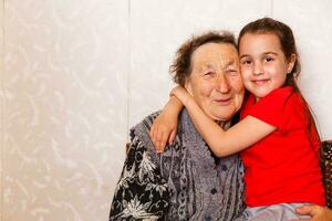 cheerful young girl taking care of an elderly woman at home photo