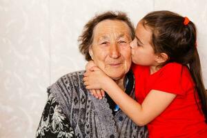 cheerful young girl taking care of an elderly woman at home photo