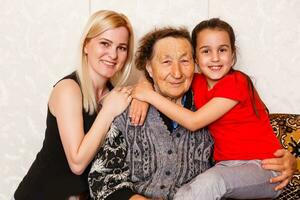 A multi generation portrait of a happy grandmother with her daughter and granddaughter spending time together photo