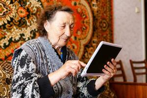 Senior woman browsing on digital tablet photo