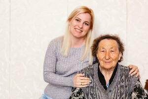 Senior woman with her caregiver at home photo