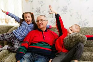 Grandparents spending time with grandchildren on couch photo