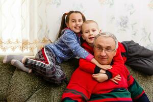 Grandparents spending time with grandchildren on couch photo