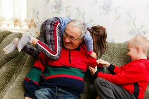 Grandparents spending time with grandchildren on couch photo