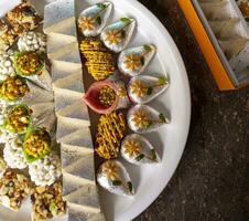 Indian Traditional Mix Sweets Food Served in Special Decorative Plate on Vintage Background photo