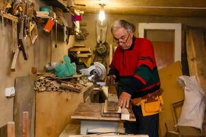Carpenter doing his job in carpentry workshop. photo