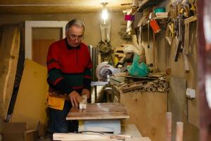 Carpenter doing his job in carpentry workshop. photo