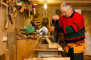 Carpenter doing his job in carpentry workshop. photo