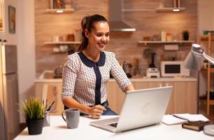 mujer de negocios reaccionando con emoción mientras trabajando en importante proyecto en el noche. empleado utilizando moderno tecnología a medianoche haciendo tiempo extraordinario para trabajo, negocio, carrera profesional, red, estilo de vida. foto