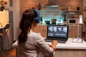 mujer trabajando con vídeo imágenes en ordenador portátil utilizando moderno software. contenido creador en hogar trabajando en montaje de película utilizando moderno software para edición tarde a noche. foto