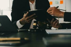 consulta y conferencia de abogados varones y empresarias profesionales que trabajan y debaten en el bufete de abogados en el cargo. conceptos de derecho, mazo de juez con balanza de justicia. foto