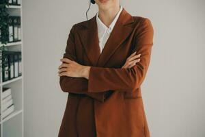 Beautiful female call center operator working on computer in office photo