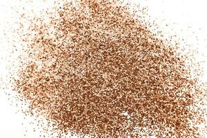 glittering background of Peach Fuzz sequins isolated on a white background closeup. photo