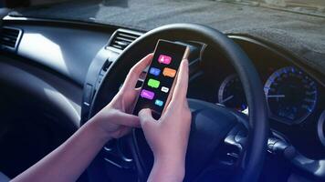 Woman using social media and digital online marketing concepts on mobile phones with icons such as notifications, messages, comments on the smartphone screen in car. photo