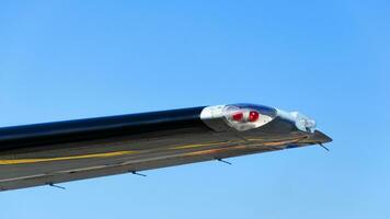 Position light on the wing of the plane, Red navigation light on left wing of jet airplane. photo