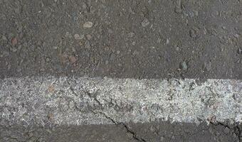 Grey asphalt with white lines. Rough cement road surface. Cracked asphalt road background. photo