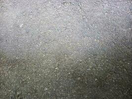 gris hormigón piso antecedentes. áspero superficie foto. desigual cemento piso. sucio la carretera textura. foto