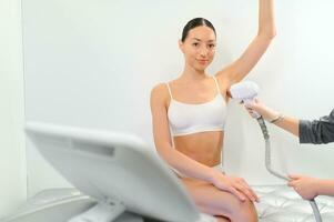 Young woman making body hair removal laser depilation in beauty center photo