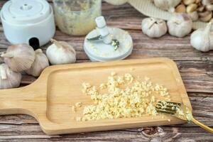 Garlic from a fine blender on a wooden plate photo