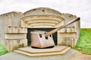 a large cannon is sitting in the middle of a concrete bunker photo