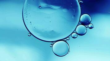El aceite de comida colorido abstracto cae burbujas y esferas que fluyen en la superficie del agua video