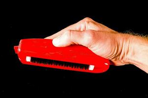 a person's hand holding a red brush photo