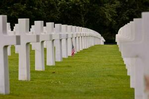 the american flag is on the grass in front of rows of white crosses photo