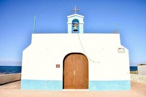 a small white church with blue trim and a bell photo