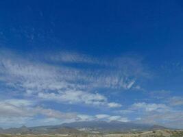 a view of the mountains and clouds from the top of a hill photo