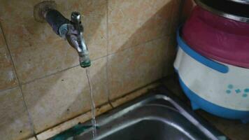 Water flows from the kitchen faucet into the sink. Improper use of water in household duties and activities. video