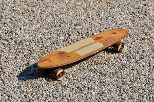 a wooden skateboard on gravel ground photo