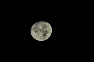 the moon is seen in the dark sky photo