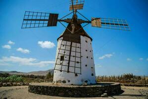 an old windmill in the middle of a desert photo