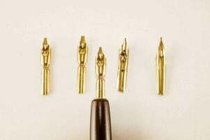 a fountain pen and four gold nibs photo