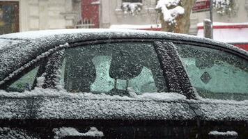 schneit beim das draußen und ein schneebedeckt Auto Fenster Detail video
