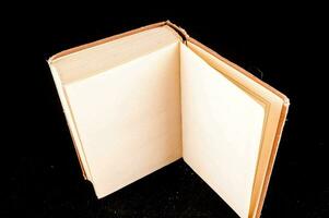 an open blank book on a black surface photo