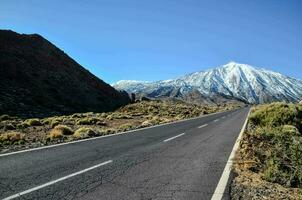 un la carretera líder a un montaña con nieve tapado picos foto