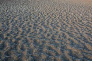 a sandy beach with ripples and waves photo