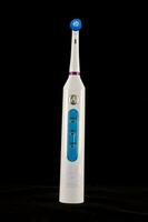 a white electric toothbrush on black photo